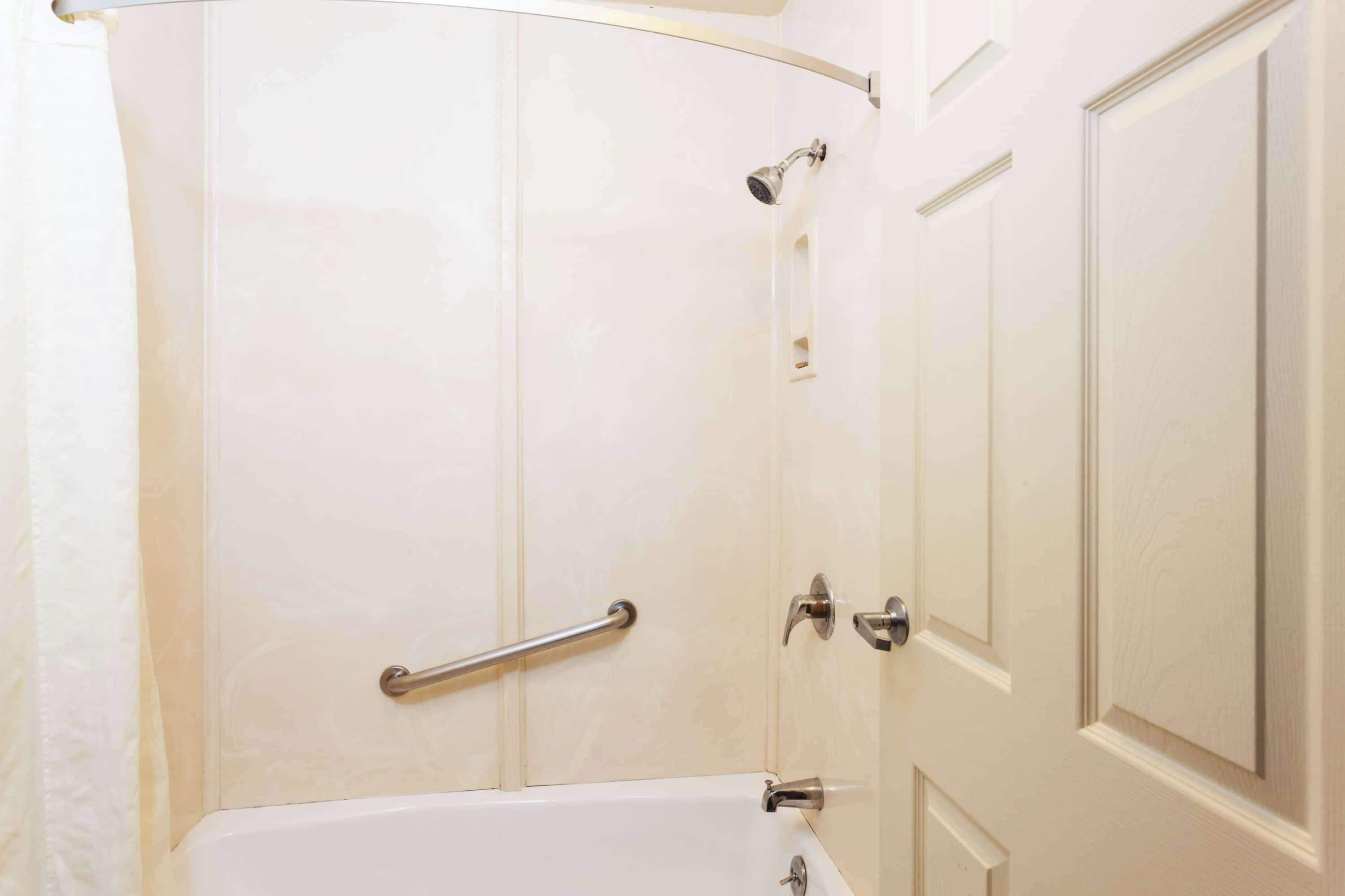 Un baño con bañera, ducha y puerta.