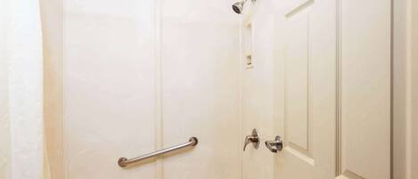 Un baño con bañera, ducha y puerta.