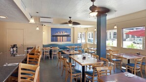 Een restaurantinterieur met zitjes, tafels en stoelen.