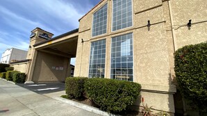 A building with a large window, a sign reading "BridgePoint Inn," and a parking lot.