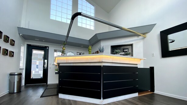 A modern kitchen with a central island, a built-in oven, and a large window above the sink.