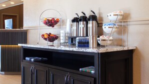 A hotel reception area with a marble counter, a coffee station, and a decorative rug. - Mountain Home Inn (Mountain Home)