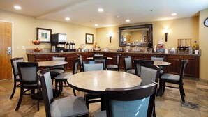 A hotel kitchen with a central island, multiple chairs, and a dining table. - Mountain Home Inn (Mountain Home)