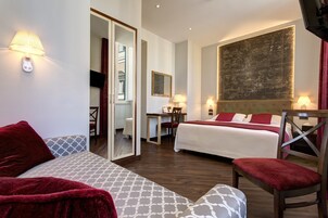 A hotel room with two beds, a sofa, a desk, and a large map on the wall.