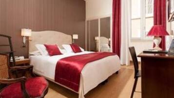 A hotel room with a bed, a desk, and a chair.