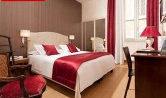 A hotel room with a bed, a desk, and a chair.