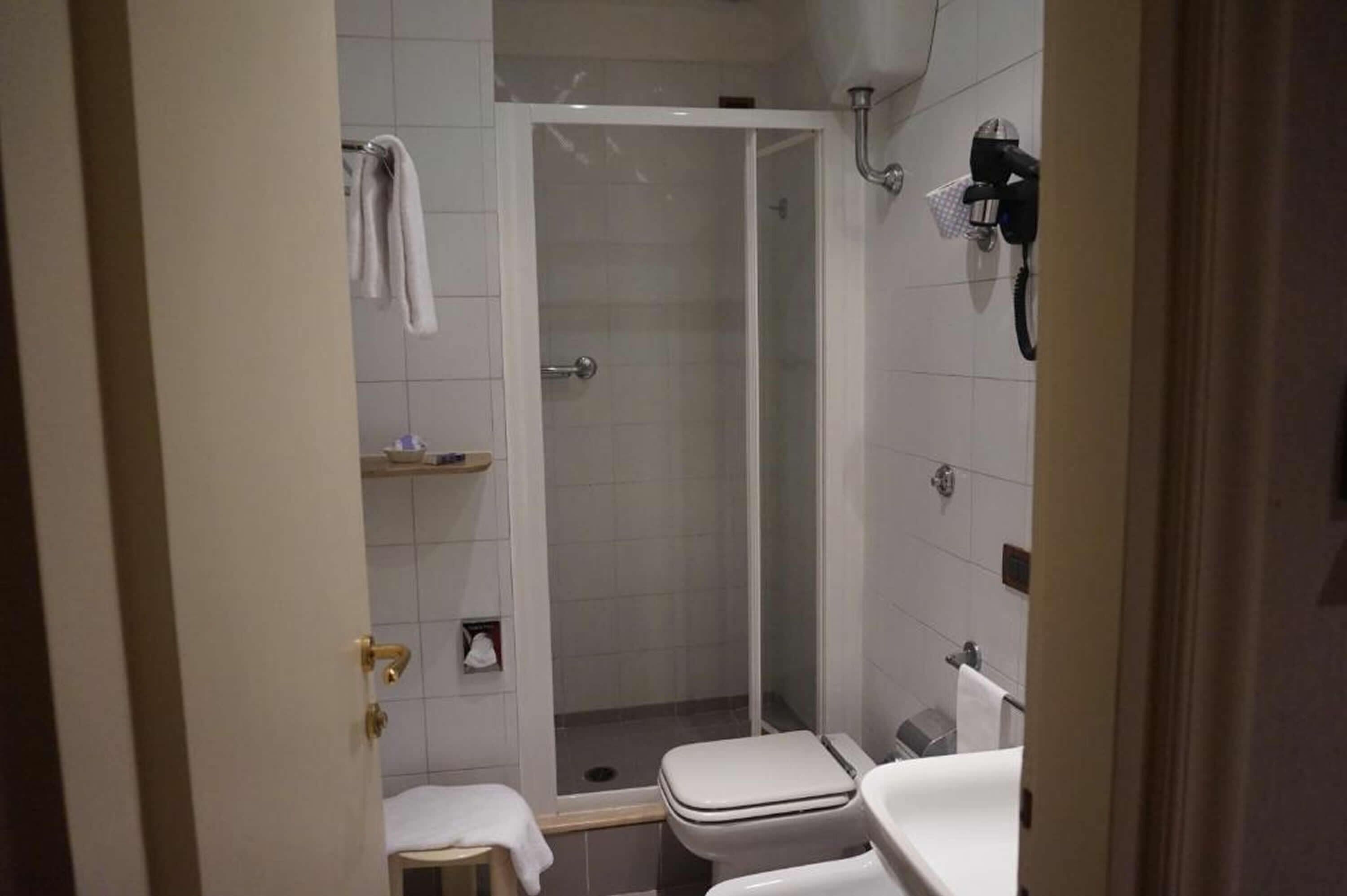 A bathroom with a shower, toilet, and sink.