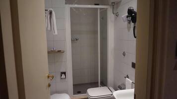 A bathroom with a shower, toilet, and sink.