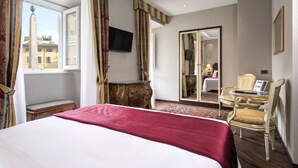 A hotel room with a large bed, a desk with a chair, a television, and a mirror. - Hotel Nazionale (Rome)