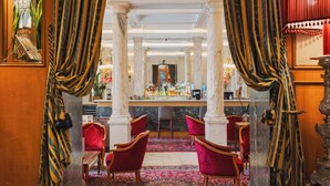 A bar area with a marble counter, red chairs, and a patterned carpet. - Hotel Nazionale (Rome)
