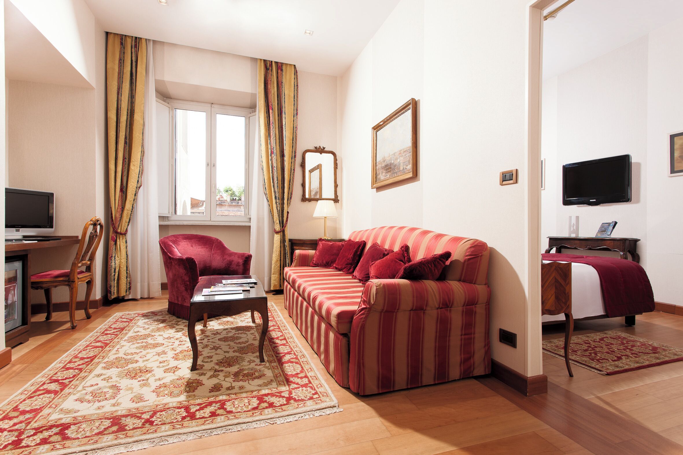Een woonkamer met een bank, fauteuil en een televisie.