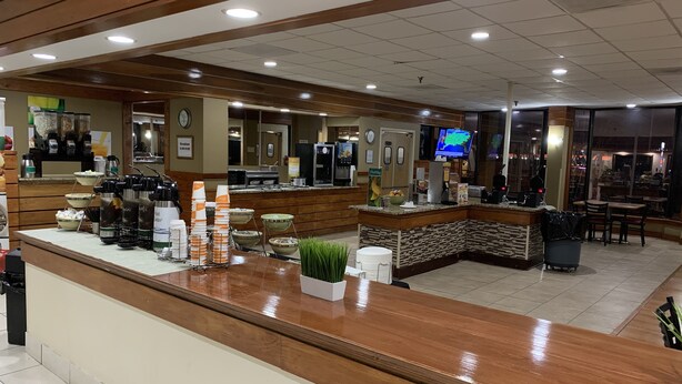 A hotel lobby with a reception desk, coffee station, and seating area. - Quality Inn & Suites Pensacola Bayview (Pensacola)