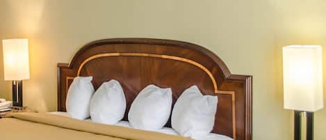 Une chambre d’hôtel avec un lit, deux lampes de chevet, une table de chevet et une table surmontée d’un plateau en marbre.