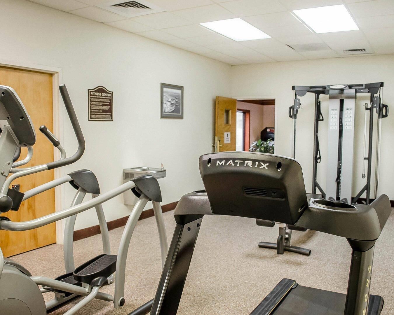 Un centre de remise en forme équipé de tapis de course, d’un vélo d’appartement et d’une machine de musculation.