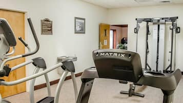 Un centre de remise en forme équipé de tapis de course, d’un vélo d’appartement et d’une machine de musculation.