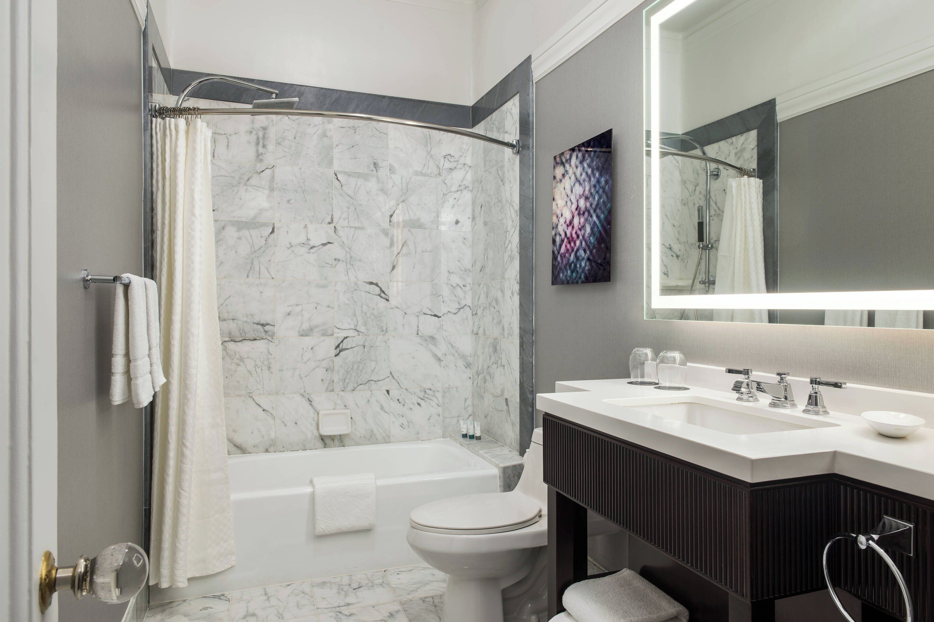A modern bathroom with a bathtub, toilet, and vanity.