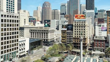 A cityscape with modern high-rise buildings, a prominent Tiffany & Co. store, and a large billboard.