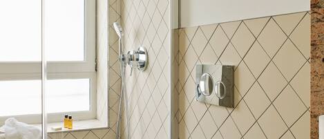 A bathroom with a glass-enclosed shower, a toilet, and a sink with a marble countertop.