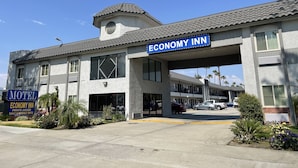 Un motel con un letrero que dice "Economy Inn" y "Jacuzzi Privado, tarifas diarias y semanales".