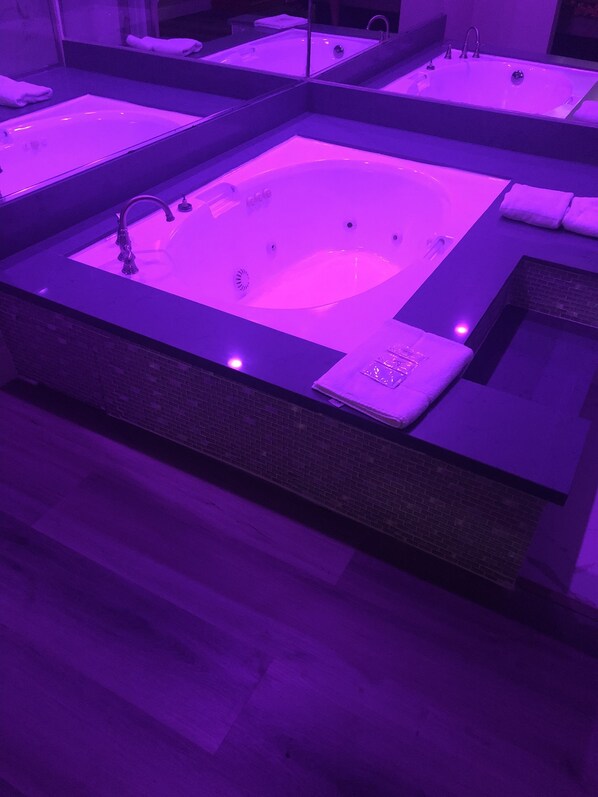 A spa area with multiple tubs and a large central tub, each with a separate entry point. - Economy Inn - Ontario Airport/Chino (Ontario)