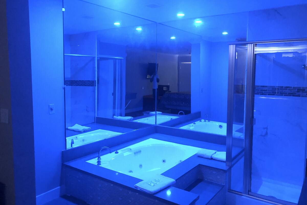Une salle de bain moderne avec un grand miroir, deux vasques et une douche à l’italienne.
