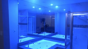 Un baño moderno con un espejo grande, dos lavamanos y una cabina de ducha de vidrio.