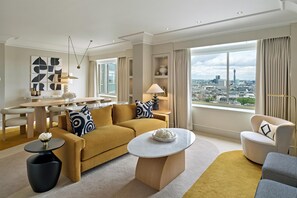 A modern living room with a sofa, coffee table, and a city view. - London Hilton on Park Lane (London)