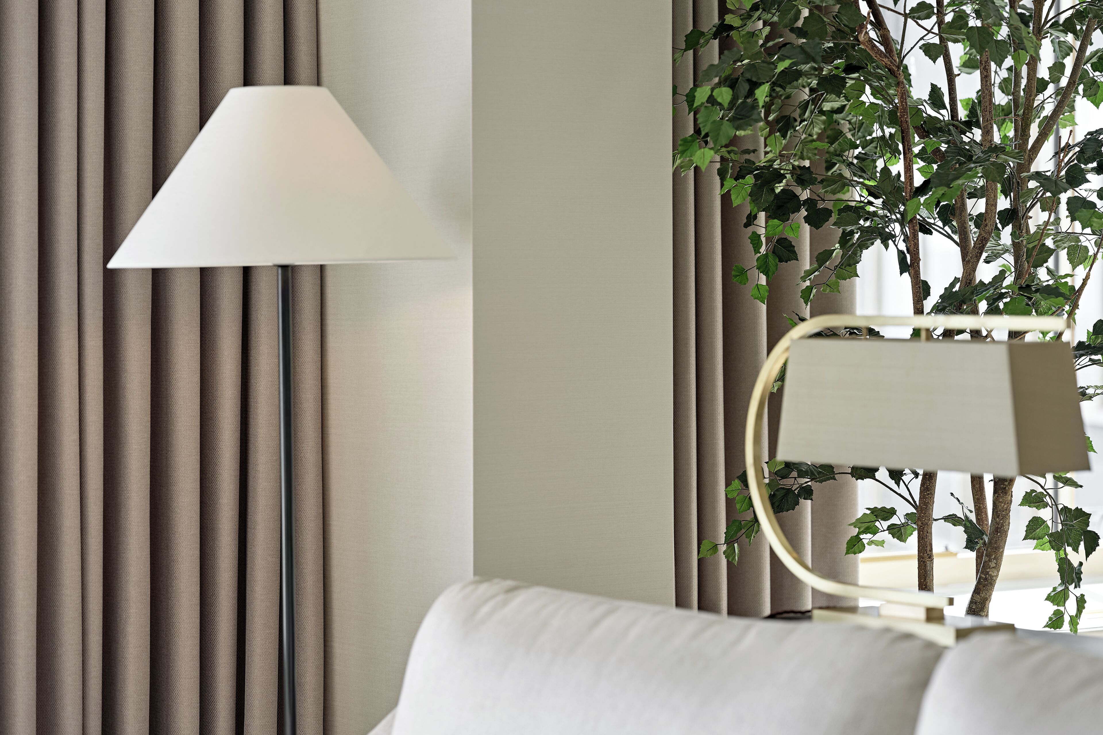 A room with a bed, a lamp, curtains, and a plant.