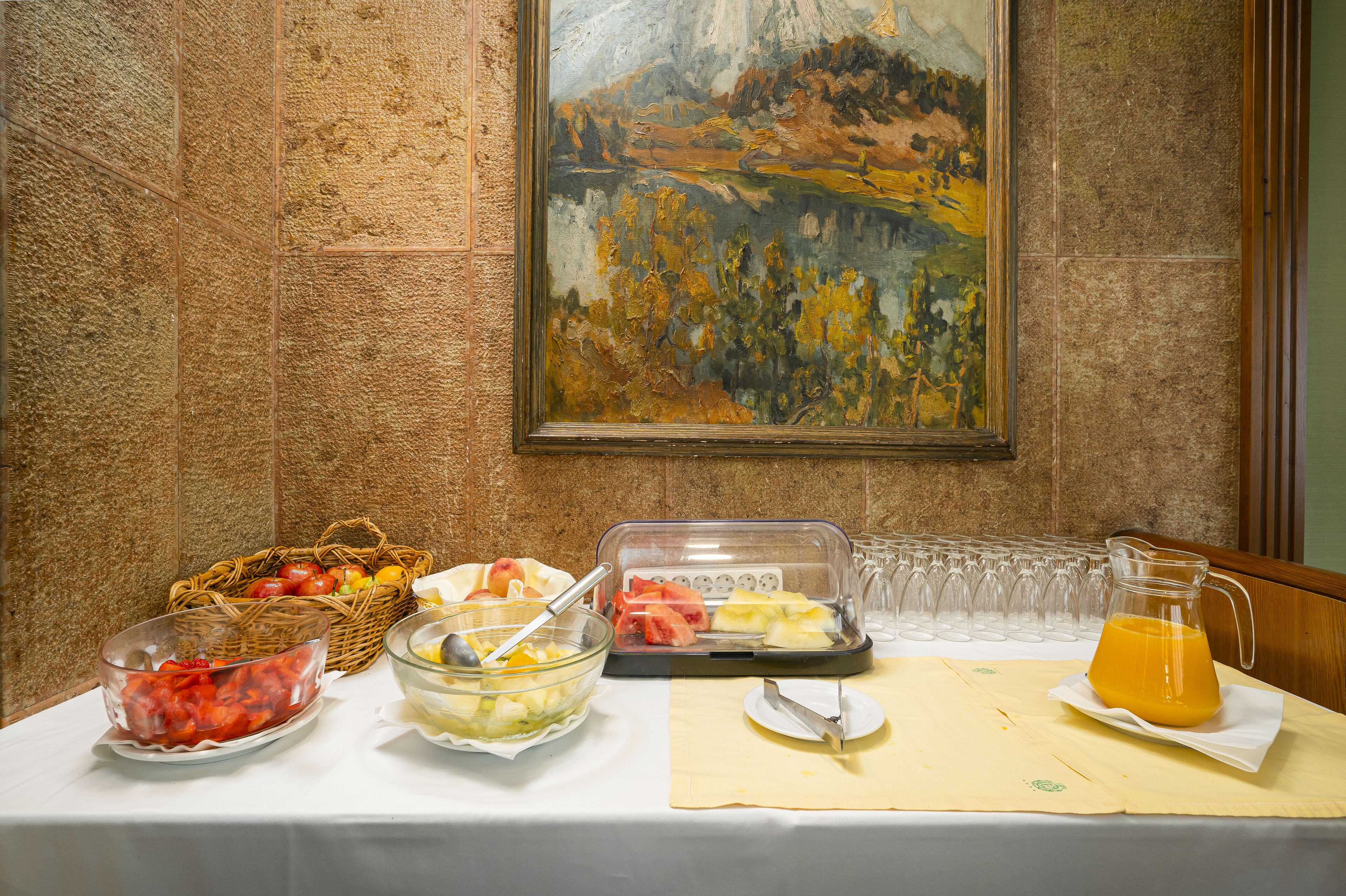 Una mesa de buffet con diversos alimentos y un cuadro en la pared.