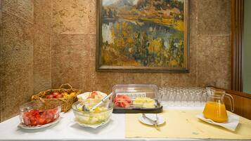 Una mesa de buffet con diversos alimentos y un cuadro en la pared.