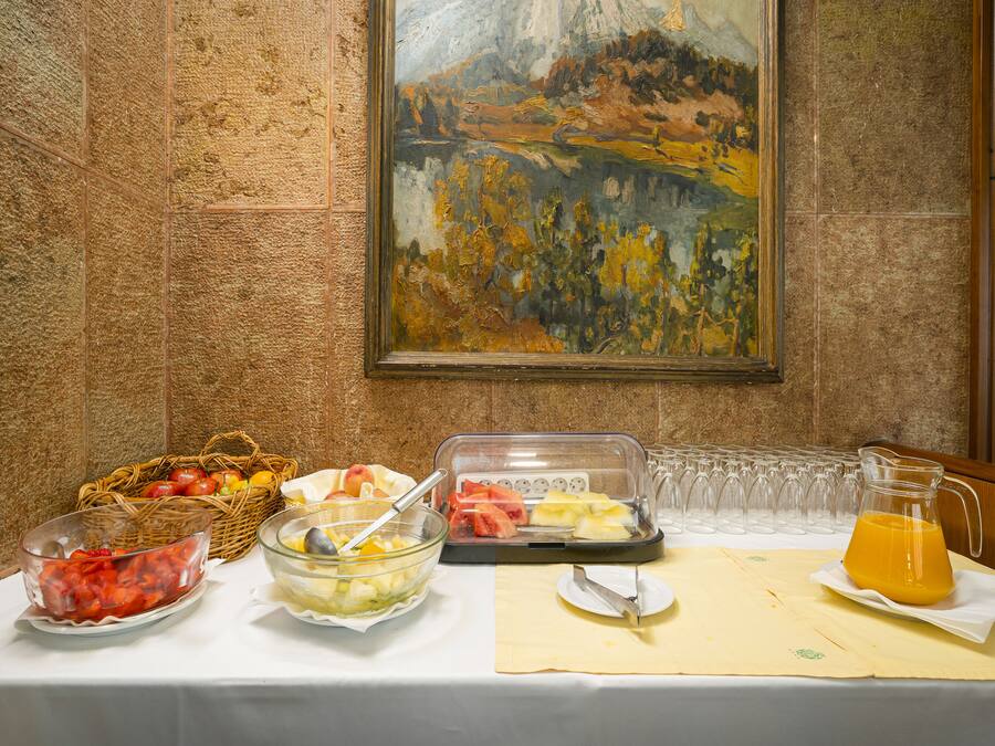 Una mesa de buffet con diversos alimentos y un cuadro en la pared.