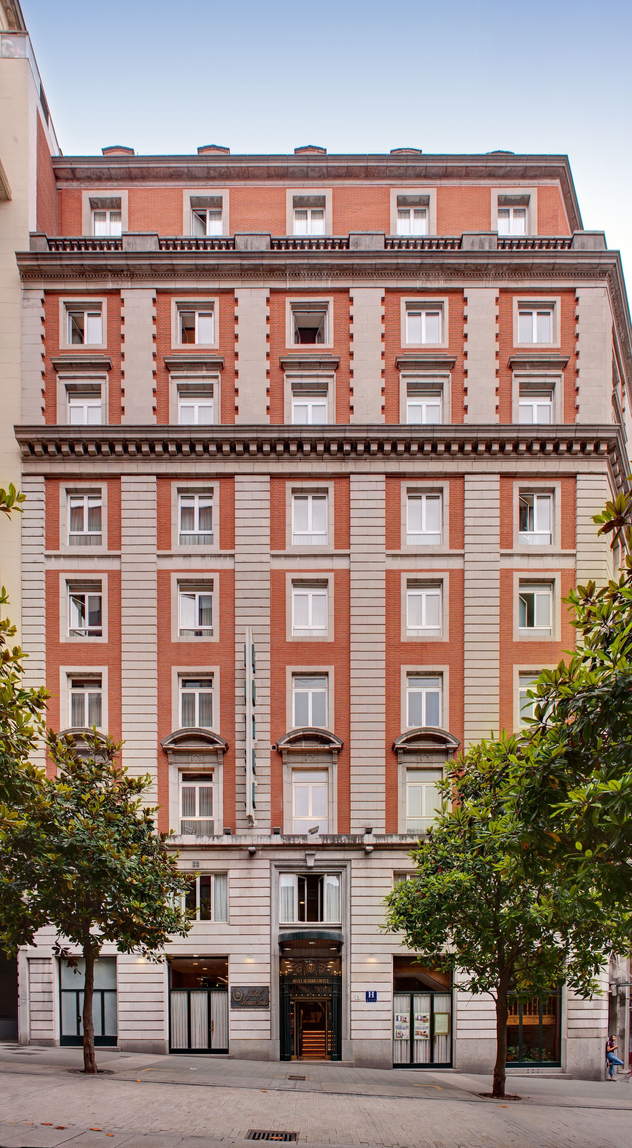 A multi-story hotel with a symmetrical facade, large windows, and a central entrance.