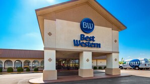 A Best Western hotel entrance with a clear sky and a parked van. - Best Western Airport (Tulsa)