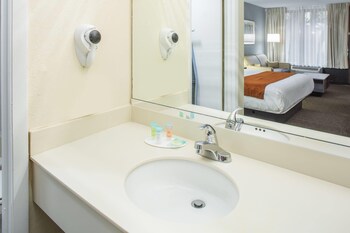 Combined shower/tub, free toiletries, hair dryer, towels at Days Inn & Suites by Wyndham Orlando Airport
