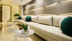 A modern living room with a sofa, two side tables, and decorative plants. - SuMa Recoleta Hotel (Buenos Aires)
