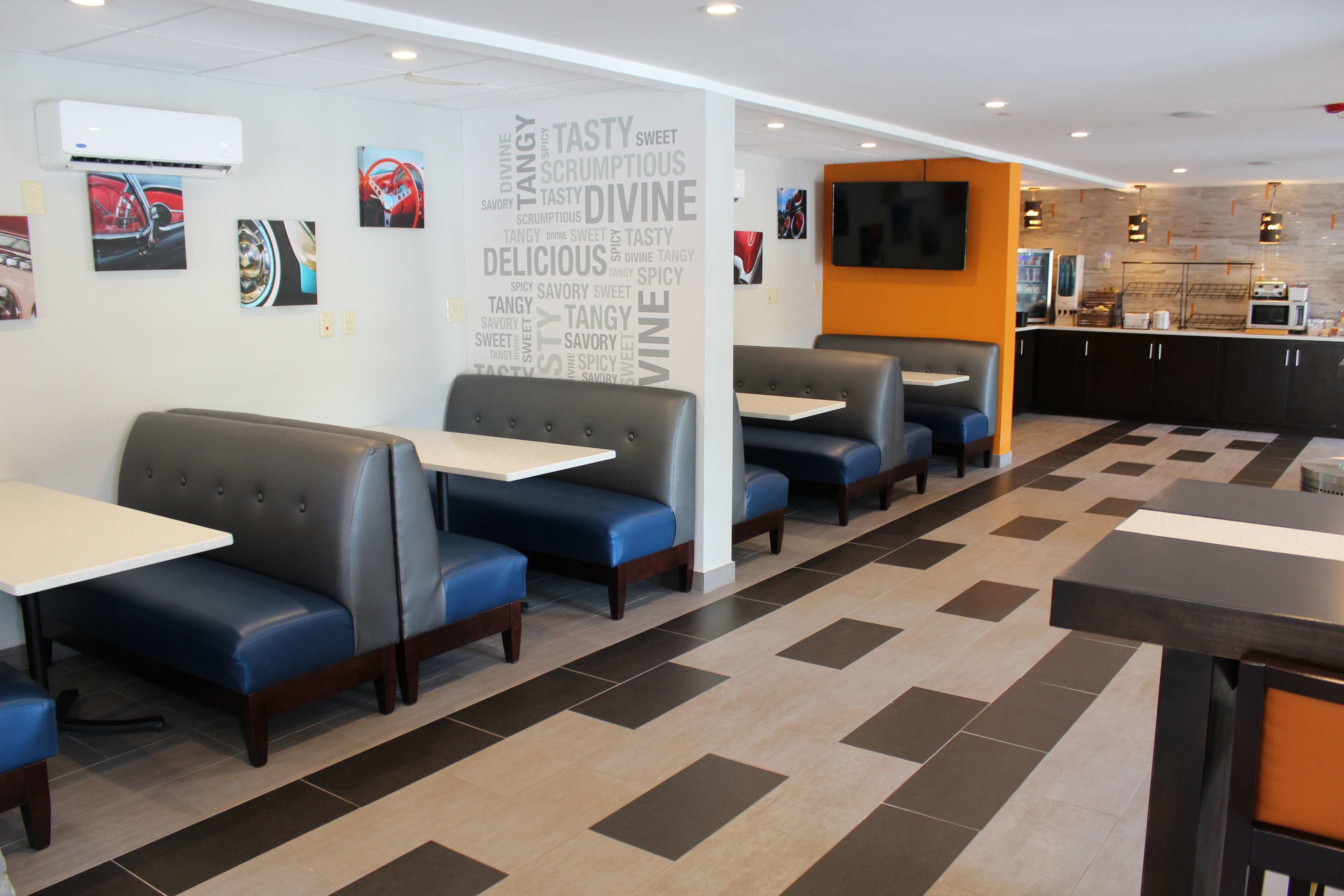 A restaurant with booths and tables, a word cloud on the wall, and a kitchen area.