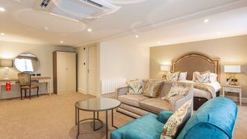 A hotel room with a bed, a sofa, a desk, and a chair.