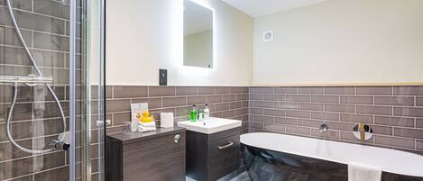 Une salle de bain moderne avec une douche à parois de verre, un meuble-lavabo et une baignoire sur pieds.