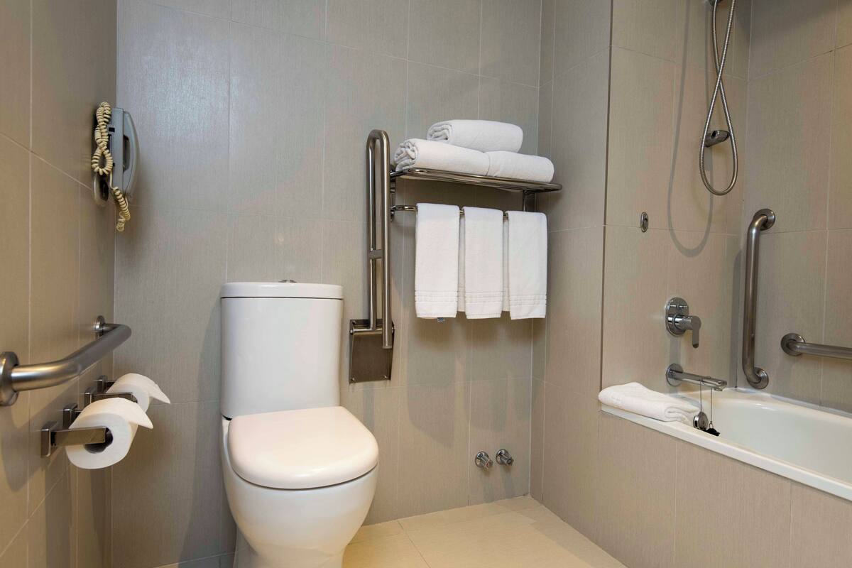 Une salle de bain moderne équipée de toilettes, d’une douche et d’une baignoire.