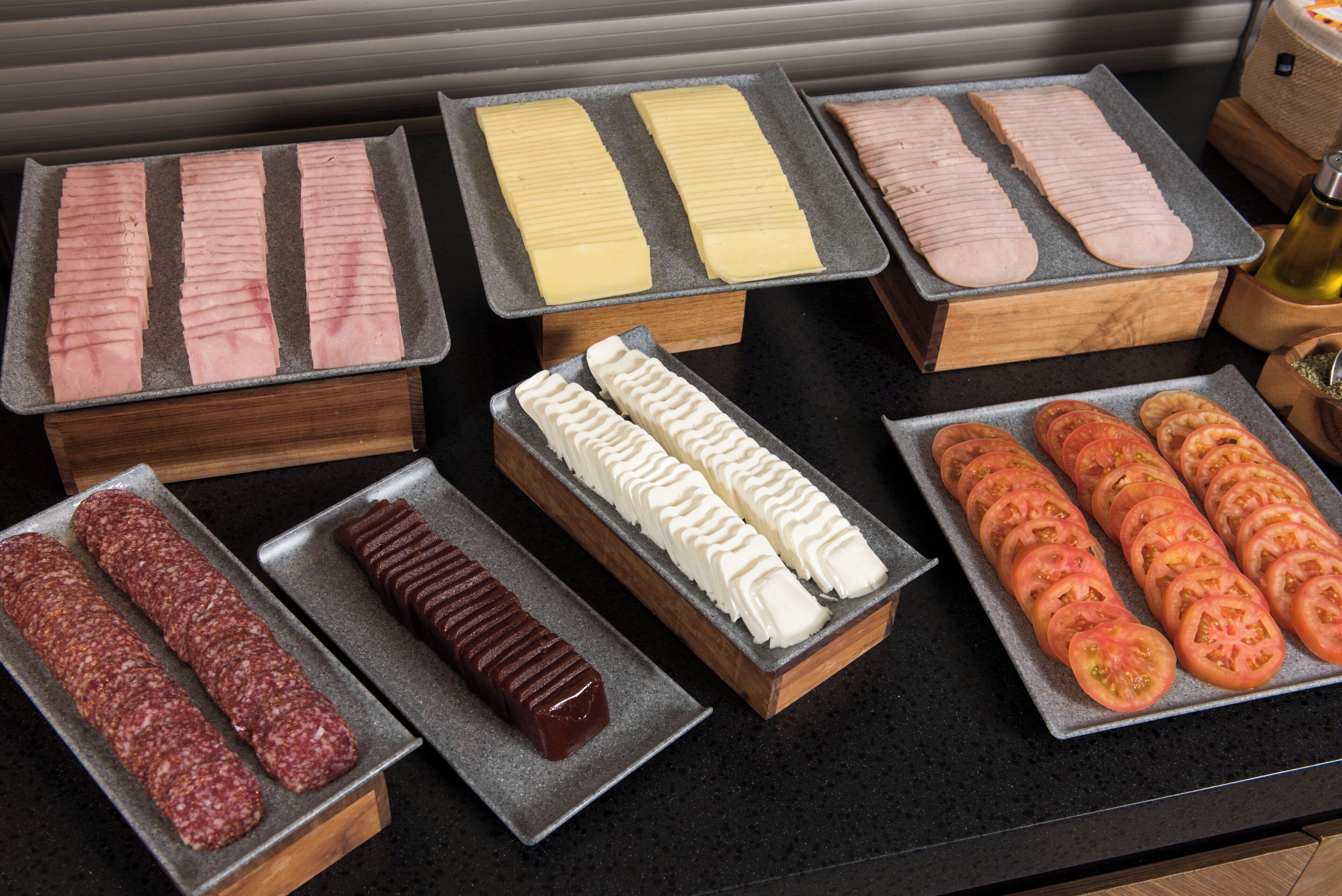 A variety of food items displayed on trays, including sliced meats and vegetables.