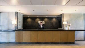 A reception desk with a modern design, featuring a dark counter and wooden panels. - Holiday Inn Express Temuco by IHG (Temuco)