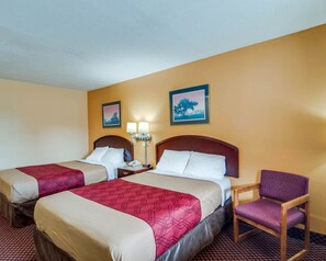 A hotel room with two beds, a chair, and two wall-mounted lamps. - Econo Lodge Near Bluefield College (Bluefield)