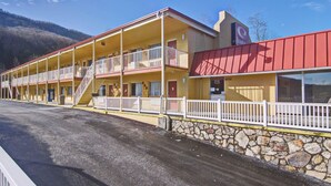 A motel with a two-story structure, a stone wall, and a red awning. - Econo Lodge Near Bluefield College (Bluefield)