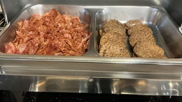 Un buffet en acier inoxydable composé de deux sections : une section avec de la viande effilochée et une autre avec des galettes.