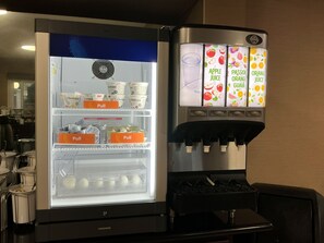 A self-service beverage dispenser with options for apple juice, passion orange guava, and orange juice. - Continental Inn San Diego Hotel Escondido (Escondido)