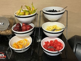 Una encimera de cocina con seis cuencos que contienen diversas frutas.