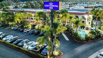A hotel with a pool, multiple parking spaces, and a sign indicating it's a Continental Inn.