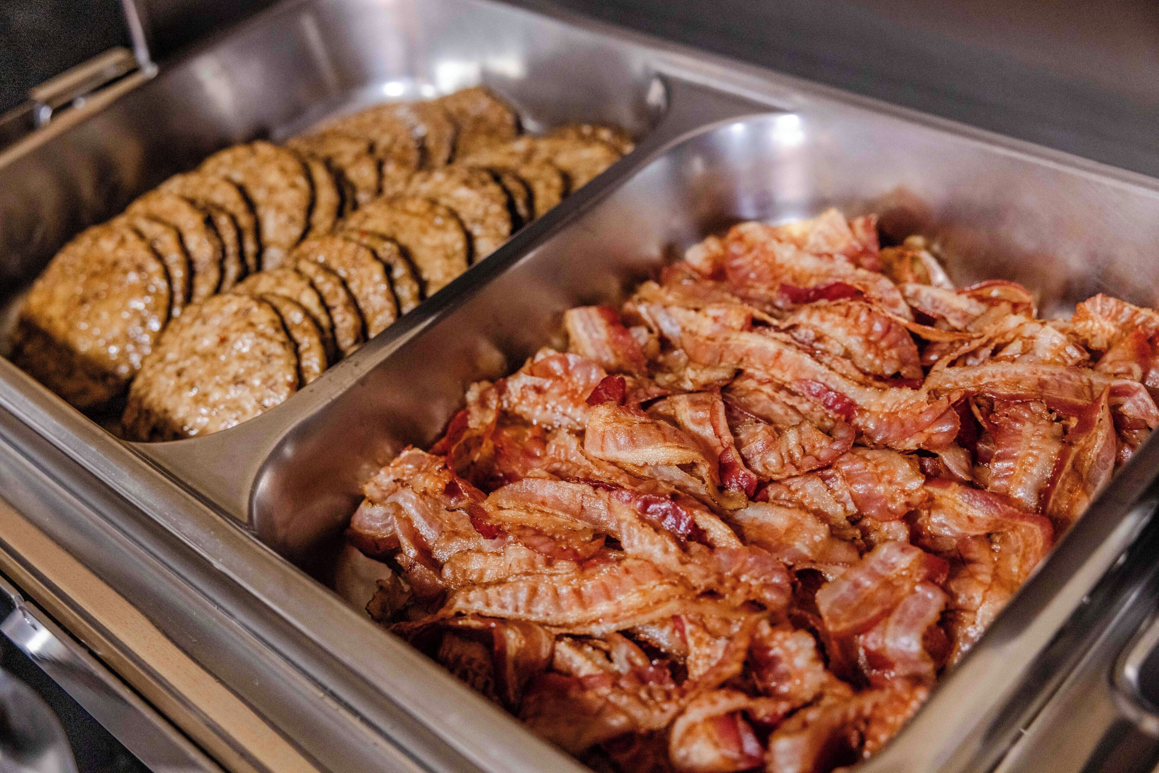 A buffet with sliced meat and bread.