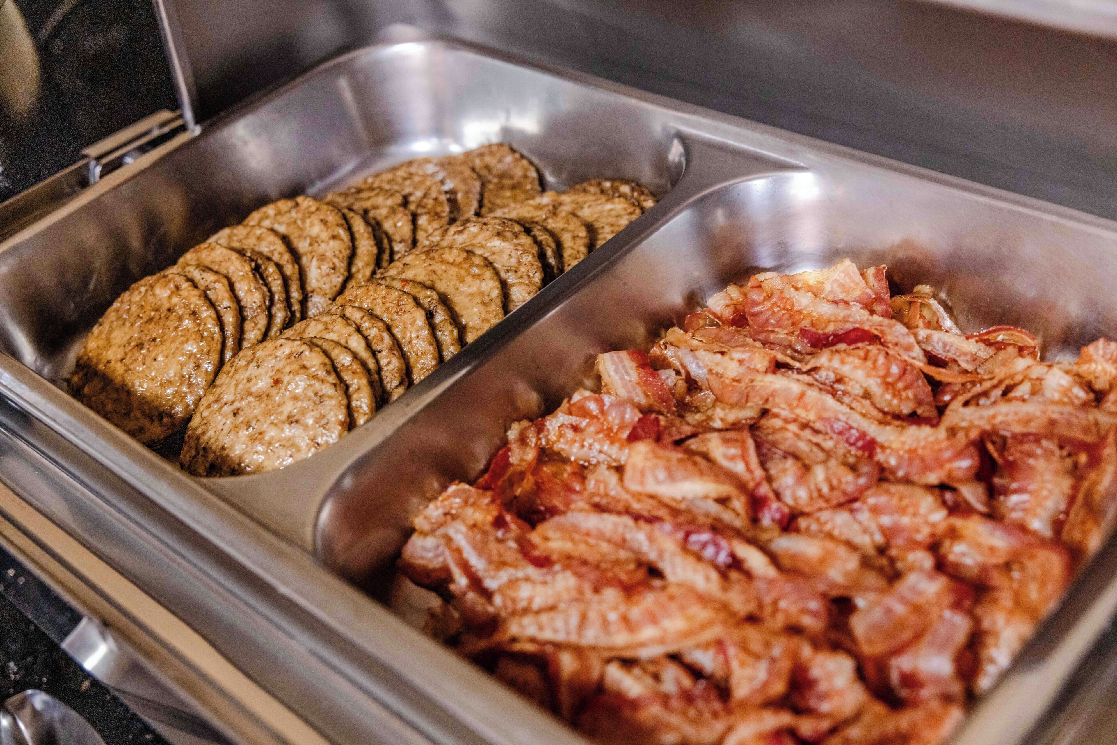 A buffet with sliced meats and vegetables.