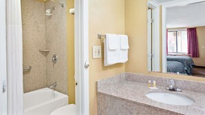 A bathroom with a bathtub, a sink, and a shower. - Days Inn by Wyndham Lawrenceville (Lawrenceville)